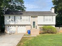 Charming two-story home featuring a two-car garage, a brick entrance, and a well-manicured lawn at 3837 Dogwood Farm Rd, Decatur, GA 30034