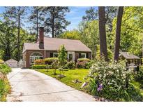 Charming brick home with a well-manicured lawn, flowering shrubs, and a classic brick chimney at 1919 Edinburgh Ne Ter, Atlanta, GA 30307
