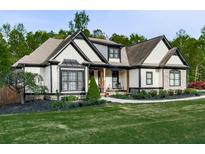Charming home showcasing a well-maintained lawn, tasteful landscaping, and attractive contrasting trim details at 1076 Pinyan Ln, Canton, GA 30115