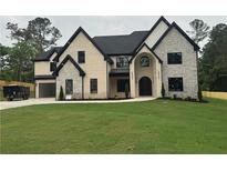 Stunning two-story home featuring stone and brick, a black roof, and black-trimmed windows at 2728 Talley Ln, Buford, GA 30519