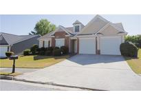 Charming single-Gathering home with a brick and tan exterior, well-manicured lawn, and a two-car garage at 7105 Boulder Pass, Union City, GA 30291