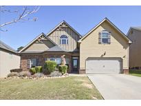 Charming two-story home with a well-manicured lawn and a two-car garage on a sunny day at 3877 Valley Bluff Ln, Snellville, GA 30039