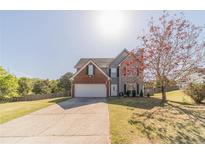 Charming two-story home with a well-manicured lawn and mature tree in a suburban neighborhood at 1542 Armende Cir, Dacula, GA 30019