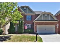 Charming two-story brick home with a manicured lawn and two-car garage on a sunny day at 2248 Fort Se Dr, Smyrna, GA 30080
