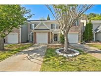 Charming townhome featuring a well-maintained lawn and an attached one-car garage at 384 Parc River Blvd, Lawrenceville, GA 30046