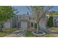 Charming townhome featuring a one-car garage, manicured lawn, and welcoming entrance at 384 Parc River Blvd, Lawrenceville, GA 30046