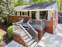 Inviting single-story home with brick facade, charming elevated porch, and well-maintained landscaping at 1211 Argonne Ne Way, Atlanta, GA 30324