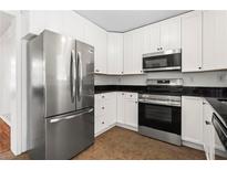 Bright kitchen features white cabinets, stainless steel appliances, and dark countertops at 1211 Argonne Ne Way, Atlanta, GA 30324