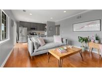 Bright living room featuring hardwood floors, gray walls, a comfortable gray sofa, and a view to the kitchen at 1705 Monroe Ne Dr # D01, Atlanta, GA 30324