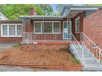Charming red brick house with a cozy covered porch and decorative white railing at 1766 Sw Brewer Sw Blvd, Atlanta, GA 30310