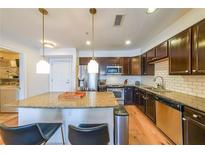 Modern kitchen with granite countertops, stainless steel appliances and a kitchen island with bar stool seating at 200 River Vista Dr # 236, Atlanta, GA 30339