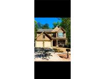 Charming two-story home boasts a two-car garage and a well-manicured lawn at 365 Friars Head Dr, Suwanee, GA 30024