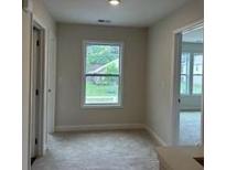 Bright hallway featuring natural light from a window, complemented by neutral walls and carpet at 3536 Dogwood Pass, Stonecrest, GA 30038