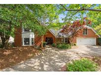 Charming red brick home with lush landscaping and a welcoming driveway at 4820 Coppedge Trl, Peachtree Corners, GA 30096