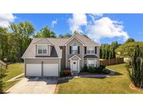 Charming two-story home with a well-manicured lawn and two-car garage at 6955 Pompas Ct, Douglasville, GA 30135