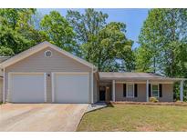 Charming single-story home with a two-car garage, well-maintained lawn and beautiful landscaping with plenty of mature trees at 1363 To Lani Farm Rd, Stone Mountain, GA 30083