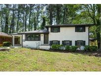 Charming, renovated home featuring a classic white painted brick exterior and mature trees at 3031 San Jose Dr, Decatur, GA 30032