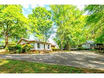 Quaint cottage-style home surrounded by lush greenery and a spacious driveway at 1098 Cown Rd, Villa Rica, GA 30180