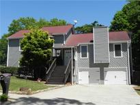 Charming gray home with a red roof, a two-car garage, and a welcoming front entrance with stairs at 2502 Kerry Ne Ct, Marietta, GA 30066