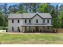 Charming two-story home with a welcoming front porch and manicured lawn at 3984 Earney Rd, Woodstock, GA 30188