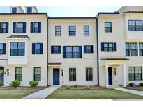 Charming white brick townhome featuring black shutters, black trim, and a stylish dark blue front door at 3677 Sorrel Ln, Duluth, GA 30096