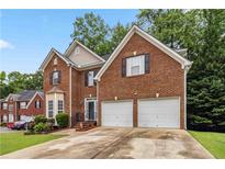 Charming brick home featuring a two-car garage and well-maintained landscaping at 3215 Rose Petal Ln, Powder Springs, GA 30127