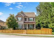 Charming two-story home with a well-maintained lawn and a quaint picket fence enhancing its curb appeal at 1976 Boyd Trace Nw Ln, Atlanta, GA 30318