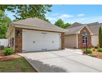 Attached two-car garage with a concrete driveway offers convenience and extra storage space at 2416 Centennial Hill Nw Way, Acworth, GA 30102