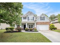 Charming two-story home with well-manicured lawn, landscaped flowerbeds and attached two-car garage at 4440 Spring Mtn Ln, Powder Springs, GA 30127