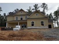 Newly constructed two-story home with modern siding, an attached garage, and a covered porch at 1041 Cottonwood Ln, Loganville, GA 30052