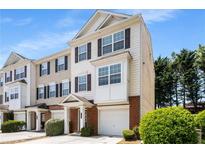 Inviting three-story townhome showcasing a charming exterior with a one-car garage and well-maintained landscaping at 2419 Ivey Crest Cir, Tucker, GA 30084