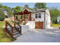 Charming renovated exterior featuring a stylish porch, wood accents, and a convenient attached garage at 2015 Cascade Sw Rd, Atlanta, GA 30311