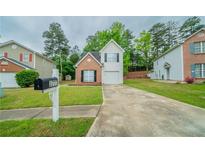 Charming two-story home with brick and vinyl siding, well-maintained lawn, and a private driveway at 3777 Oakland Spring Ct, Snellville, GA 30039