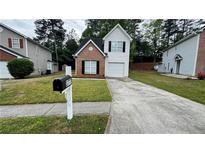 Charming home with brick accents, a well-manicured lawn, and a private driveway at 3777 Oakland Spring Ct, Snellville, GA 30039