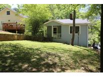 Charming exterior view showcasing a cozy blue house with a welcoming front porch and lush green lawn at 3043 Alston Dr, Decatur, GA 30032