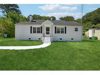 Charming single-story home with a white painted brick exterior, black shutters, and a well-manicured front lawn at 785 Alice St, Forest Park, GA 30297