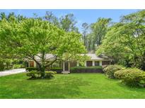 Charming single-story home featuring a lush green lawn and mature trees in a serene setting at 1237 Gale Dr, Norcross, GA 30093