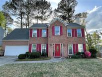 Charming brick home featuring red shutters, landscaped yard, and an attached two-car garage at 4805 Wilkie Nw Way, Acworth, GA 30102