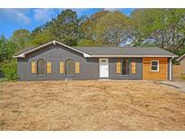 Charming grey brick home featuring arched windows and rustic wood accents at 8833 E Bourne E Dr, Jonesboro, GA 30238