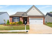 Charming brick home with manicured lawn and attached two-car garage at 806 Village Pl, Loganville, GA 30052