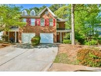 Charming two-story brick home with red shutters, a well-manicured lawn, and a two-car garage at 6125 Brookechase Ln, Norcross, GA 30093