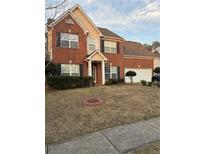 Charming two-story brick home featuring a manicured lawn and a welcoming entrance at 893 Port West Dr, Auburn, GA 30011