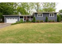 Charming home boasts a manicured lawn, complemented by a one-car garage and covered front porch at 126 N Barton St, Norcross, GA 30071