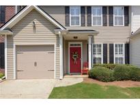 Charming home featuring a red front door, attached garage, and manicured lawn at 2557 Avery Park Cir, Atlanta, GA 30360