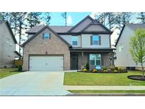 Charming two-story home featuring a brick facade, manicured lawn, and attached two-car garage at 632 Eagles Nest Cir, Auburn, GA 30011