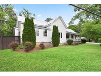 Charming home featuring a metal roof, white siding, front lawn, and well-maintained landscaping at 1830 Lost Mountain Rd, Powder Springs, GA 30127
