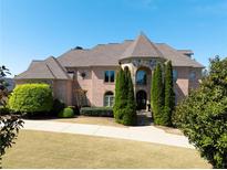 Stunning brick home with turret, manicured lawn, and mature landscaping at 8710 Merion Dr, Duluth, GA 30097