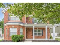 Two-story brick home featuring a covered front porch with white columns and lush landscaping at 433 Orchid Ln, Canton, GA 30114