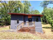 Modern home with a unique gray exterior, wood accents, and a charming wooden deck and railing at 1092 Hillcrest Se Dr, Atlanta, GA 30316