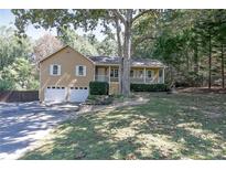 Charming home featuring a well-maintained front yard, covered porch, and attached two-car garage at 304 N Briar Rdg, Woodstock, GA 30189